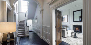 This image shows the entry foyer and entrance to the main reception room of this renovated, listed villa in St John's Wood, London.