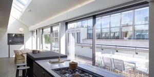 This image shows the kitchen, dining area and large terrace of one of the three luxury duplex apartments in Central London.