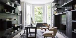 This image shows the refurbishment of the Little Venice, London historic property. It is the view of the home office. We restored the wall panelling, refurbished the white marble fireplace and installed new oak flooring laid in a chevron pattern. The room features important mid-Century modern furniture. We designed the modern bookshelves and unit to house the TV. This image exemplifies our modern approach to the design and refurbishment of historic properties in Europe.