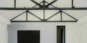 This image shows a detail of the restored trusses with the spotlights for art in the loft apartment.